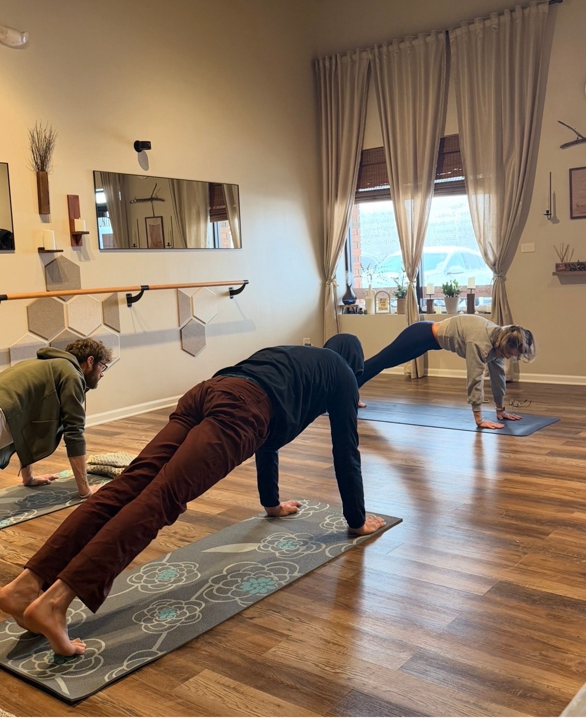 Yoga and movement class at Mindful Way Studio in Mokena IL — students in plank pose on mats in a bright barre studio