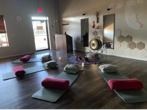 A peaceful yoga studio with mats, cushions, and soft lighting.